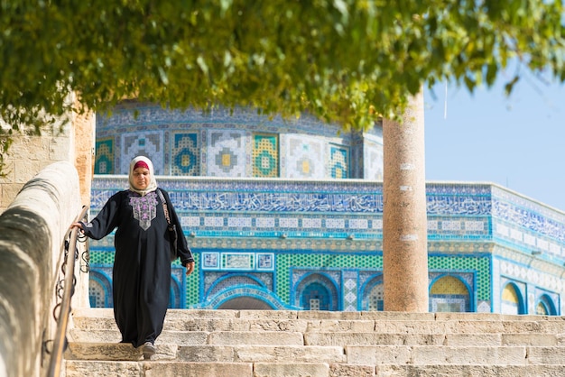 Arabische Frau steigt nach dem Besuch der Felsendom-Moschee die Treppe hinunter