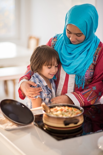 Arabische junge Frau mit Kleinkind in der Küche