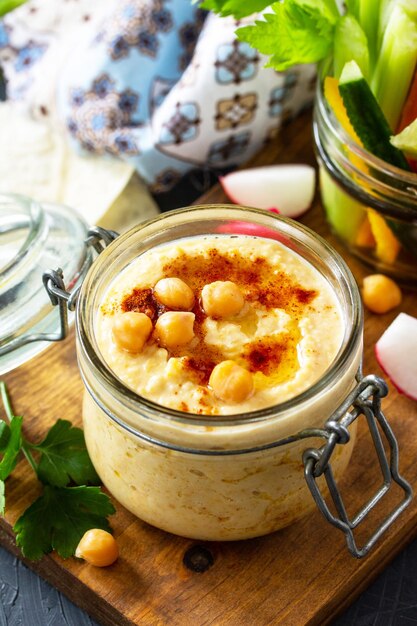 Arabische Küche Nahost-Hummus mit Snacks Hummus-Dip mit frischen Gemüsesticks auf einer Arbeitsplatte aus dunklem Stein