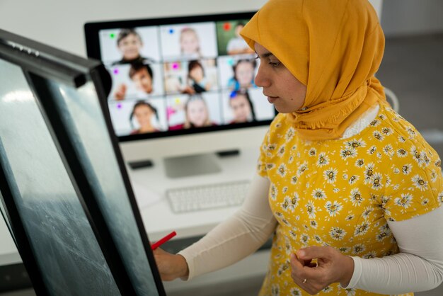 Arabische Lehrerin, die während einer Pandemie mit Kindern in der Online-Schule arbeitet