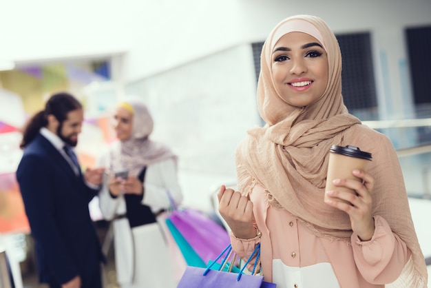 Arabische Leute, die mit Kaffee im Mall nach dem Einkauf stehen