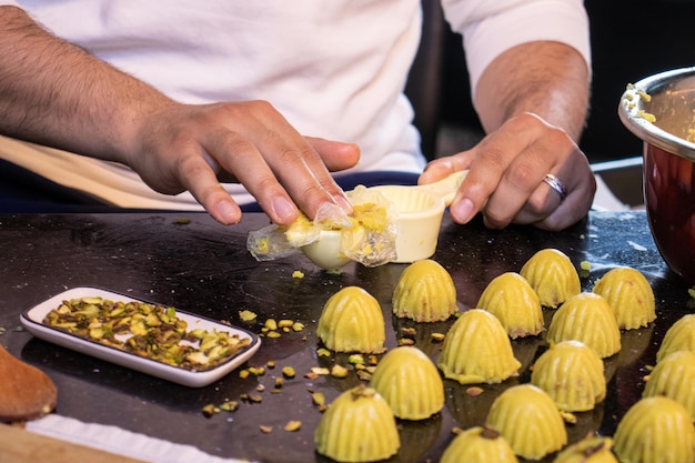 Arabische Männerhände, während sie zu Hause Keto Eid Kahk machen