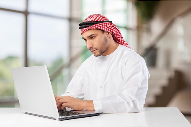 Arabischer Geschäftsmann, der Kaffee in seinem Büro trinkt