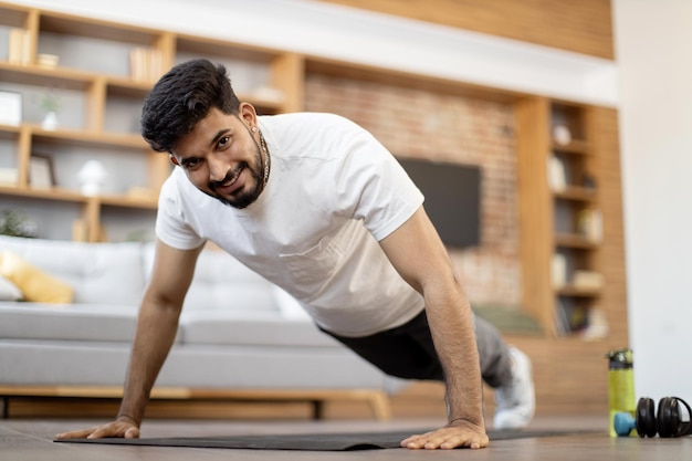 Foto arabischer mann, der im wohnzimmer in plankenposition steht