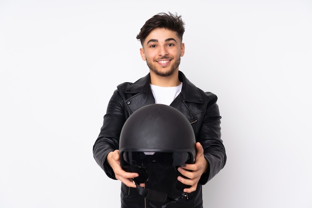 Foto arabischer mann mit einem motorradhelm lokalisiert auf weißer wand mit glücklichem ausdruck