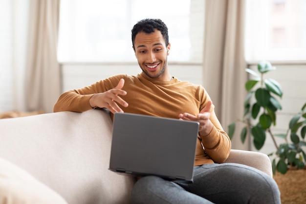 Arabischer Mann mit Laptop und Headset am Schreibtisch