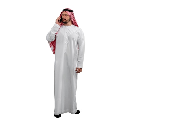Arabischer Mann telefoniert isoliert auf weißem Hintergrund in traditioneller Tracht. Bereit zum Schneiden und Bearbeiten
