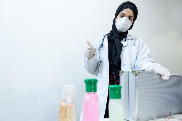 Arabischer muslimischer Arzt mit Maske und Präsentation von Hygiene- und Schutzprodukten