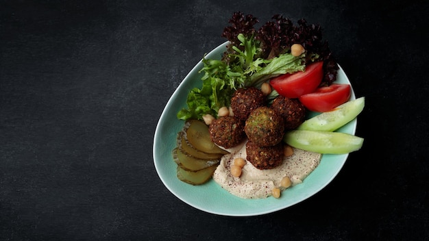 Arabisches Essen Hummus und Falafel mit frischem Gemüse auf grauem Beton