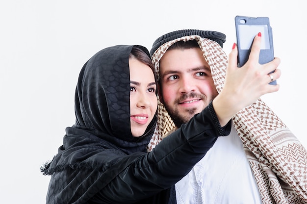 Arabisches Paar macht Selbstfotos mit Verkaufstelefon. Selfie.