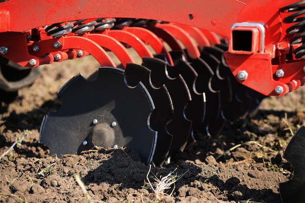 Arado agrícola primer plano en el suelo, maquinaria agrícola.