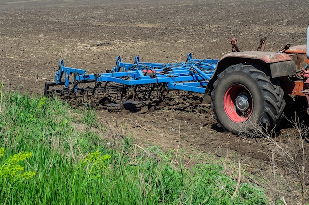 Arado anexado a um trator em um campo