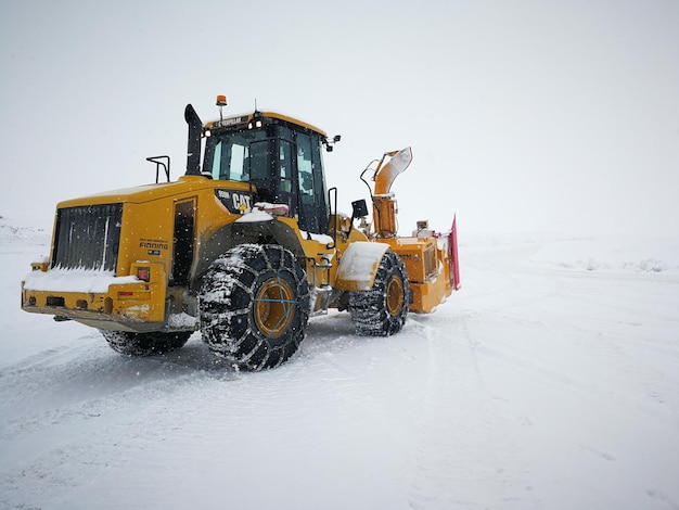 El arado de nieve en el campo contra un cielo despejado