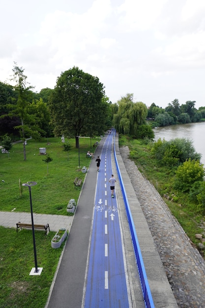 AradRumänien 20. Juli 2021 Fahrradweg Radweg im Park Menschen auf dem Fluss von Elektrorollern