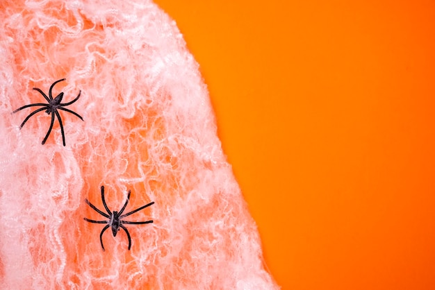 Arañas negras en una telaraña sobre un fondo naranja de Halloween Diseño Todos los Santos39 Día Arañas de plástico Imitación de una telaraña Vacaciones Octubre Interior Jack o linterna truco o trato