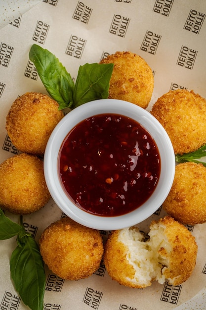 Arancini Comida y salsa de tomate Bolas de arroz frito con salsa picante dulce Cocina siciliana