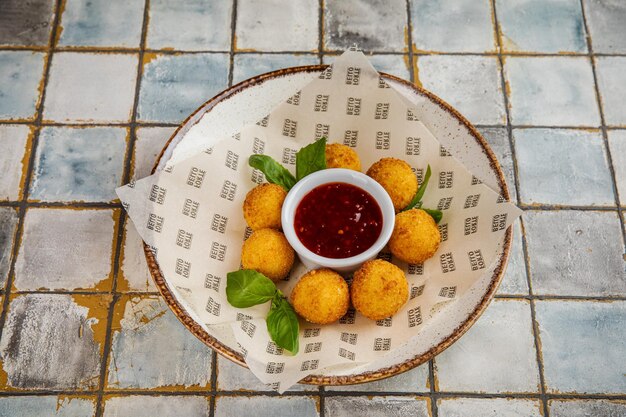 Arancini Comida y salsa de tomate Bolas de arroz frito con salsa picante dulce Cocina siciliana