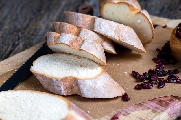 Arándano y baguette suave y fresca en rodajas sobre una tabla para cortar y una mesa