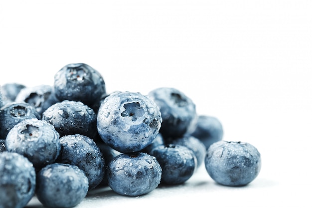 Arándanos aislados en un blanco. Un esparcimiento de frutos rojos maduros, jugosos, deliciosos y saludables.