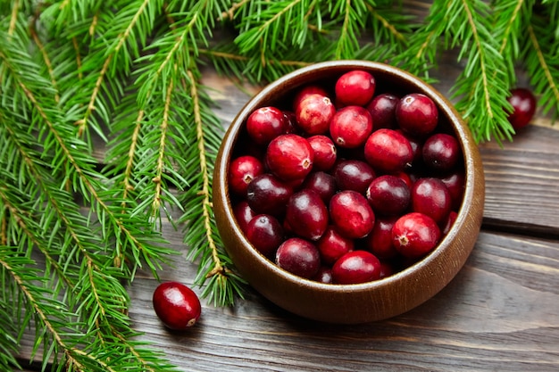 Arándanos bayas frescas en un tazón de madera en la mesa con ramas de árboles de Navidad