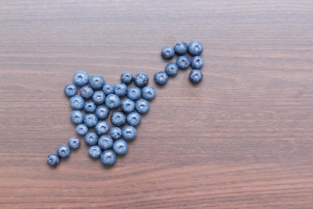 Arándanos dispuestos sobre una tabla de madera en forma de corazón