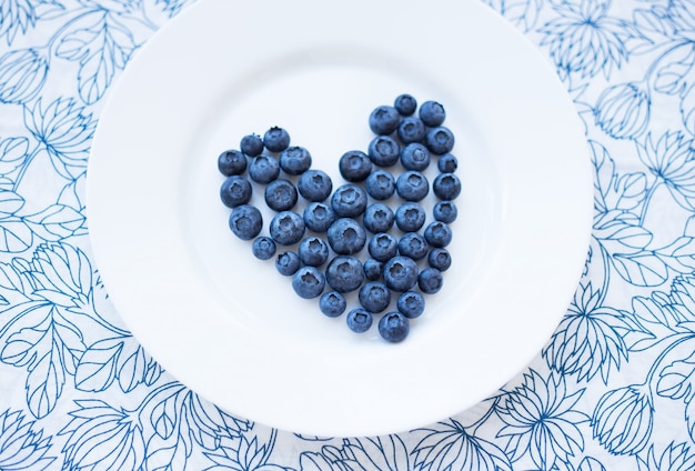 Arándanos en forma de corazón en un plato blanco