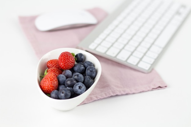 Arándanos y fresas en el espacio de trabajo.