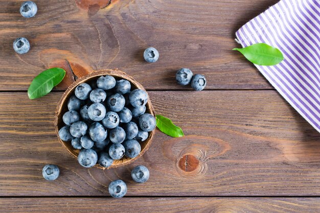 Arándanos frescos en un recipiente sobre una mesa de madera Superalimento orgánico salvaje Vista superior