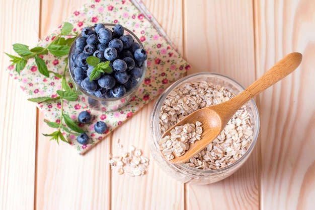 Arándanos frescos en un vaso de copos de avena