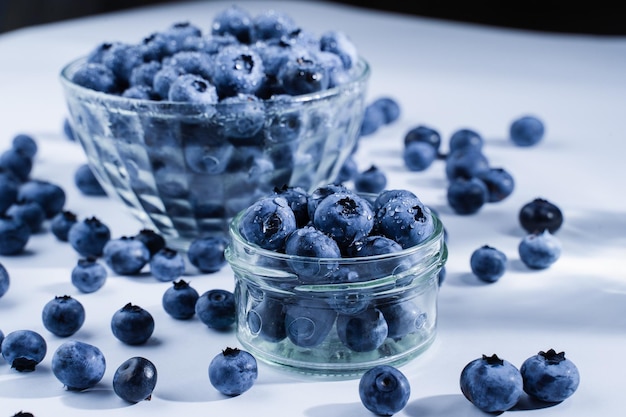 Arándanos con gotas de agua Blueberry en placa de vidrio y sobre la mesa sobre fondo blanco Muchos arándanos orgánicos naturales