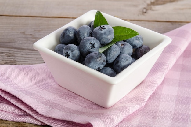 Arándanos en un plato de porcelana sobre fondo de madera