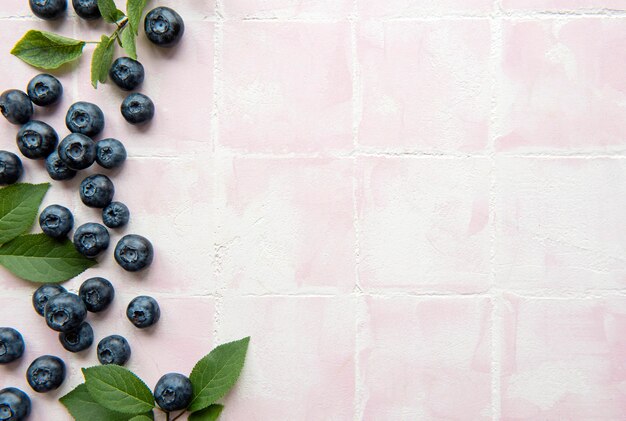 Arándanos recién cosechados sobre un fondo de mosaico rosa. Concepto de alimentación saludable