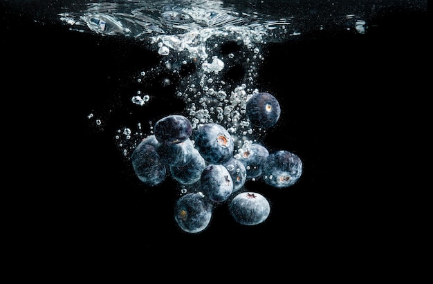 Los arándanos salpicando en el agua en negro