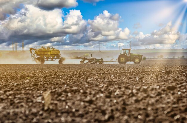 Foto arar o campo com um trator, arar o solo, cultivar a terra cultivada e cultivar o solo