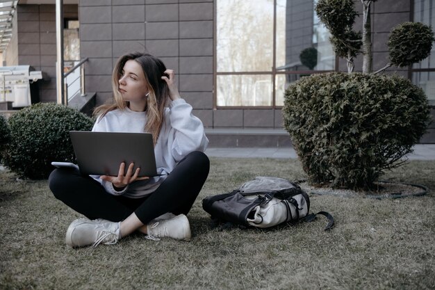 Arbeit im Freien Frau, die am Laptop im Park arbeitet Entfernte Fernarbeit während der Quarantäne Coronavirus covid19