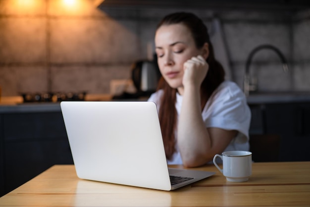 Arbeit im Küchenbüro Fernarbeit von zu Hause aus Junge Frau mit Laptop Freiberufler Arbeitsplatz am Küchentisch Fernunterricht