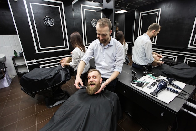 Arbeit in einem Friseurladen. Zwei Meister bei der Arbeit.