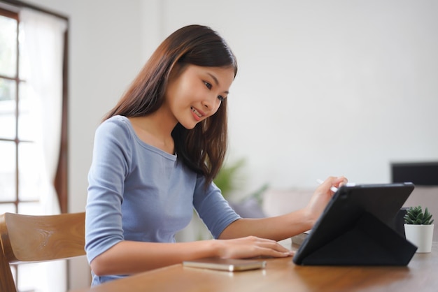 Arbeit von zu Hause aus Geschäftsfrauen lesen Finanzdaten auf dem Tablet, um im Wohnzimmer zu arbeiten