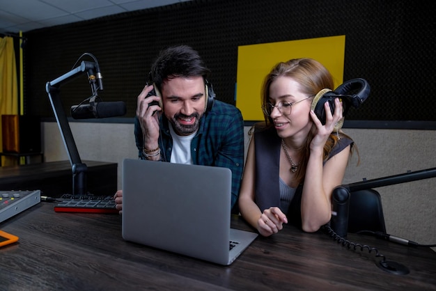 Arbeiten am Radio. Zwei Teammitglieder beim Soundcheck und engagiert wirkend