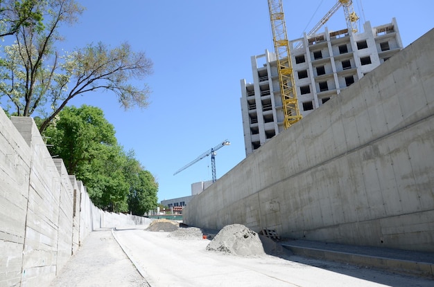 Arbeiten an hohen Kränen im Inneren mit hohen Gebäuden im Bau