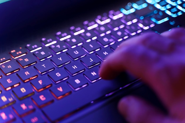 Arbeiten an Neon-Computertastatur mit farbiger Hintergrundbeleuchtung Hacking-Technologie für Computer-Videospiele