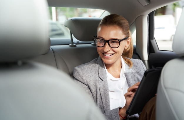 Arbeiten auf dem Weg zum Büro erfolgreiche Geschäftsfrau mit Brille mit digitalem Tablet