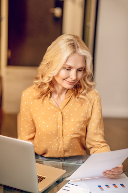 Arbeiten. Blonde stilvolle Geschäftsfrau, die am Laptop arbeitet