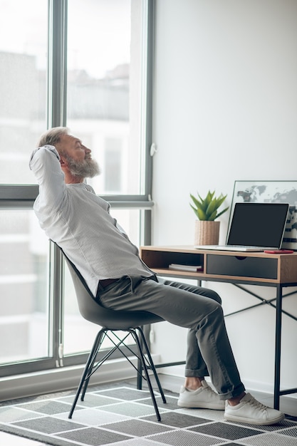 Arbeiten . ein reifer selbstständiger mann, der zu hause arbeitet und müde aussieht