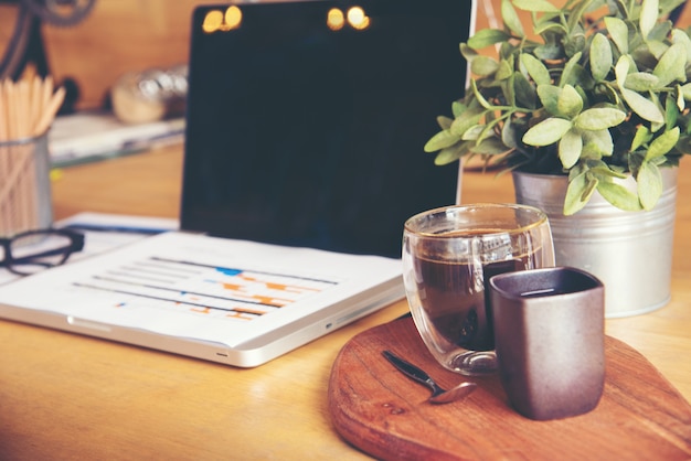 Arbeiten im Büro mit Anzeigen von Handmarktberichtsdiagrammen. Marketingabteilung Planung neuer Strategie. Forschungsprozess Holztabelle. Horizontal. Unscharfer Hintergrund. Filmeffekt.