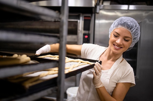 Arbeiten in der Backwarenproduktion und bereiten rohes Brot und Gebäck zum Backen vor