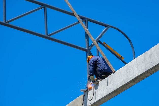 Arbeiten in der Höhe, Mann Schweißen Struktur des Fabrikdaches in Baustelle, Besetzung mit hohem Risiko.