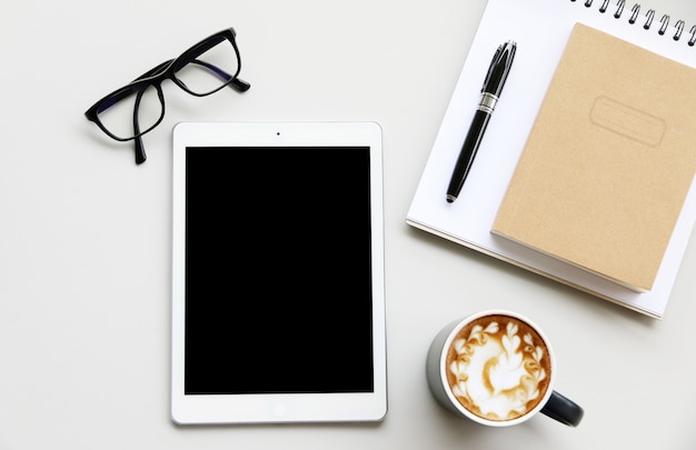 Foto arbeiten mit tablet-computer und kaktuskopierplatz auf tabellenhintergrund. draufsicht