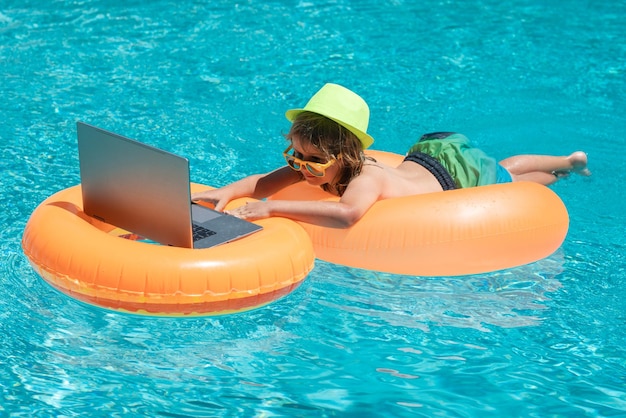 Arbeiten und Entspannen am Strand Kind arbeitet am Laptop aus dem Schwimmbad Sommergeschäft