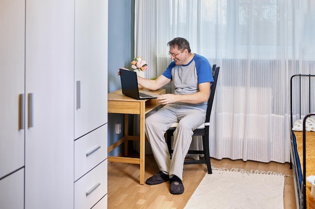 Arbeiten von zu Hause oder Telearbeit für reife Männer mit Laptop